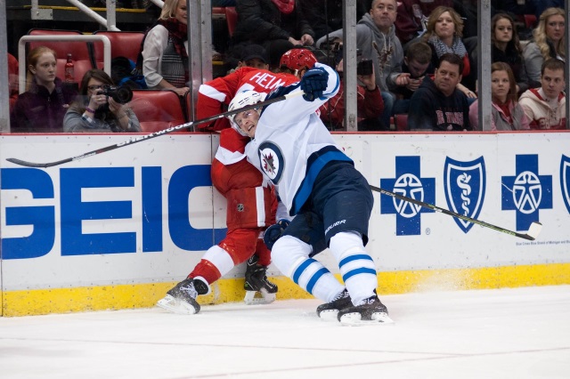 Jacob Trouba of the Winnipeg Jets and Darren Helm of the Detroit Red Wings