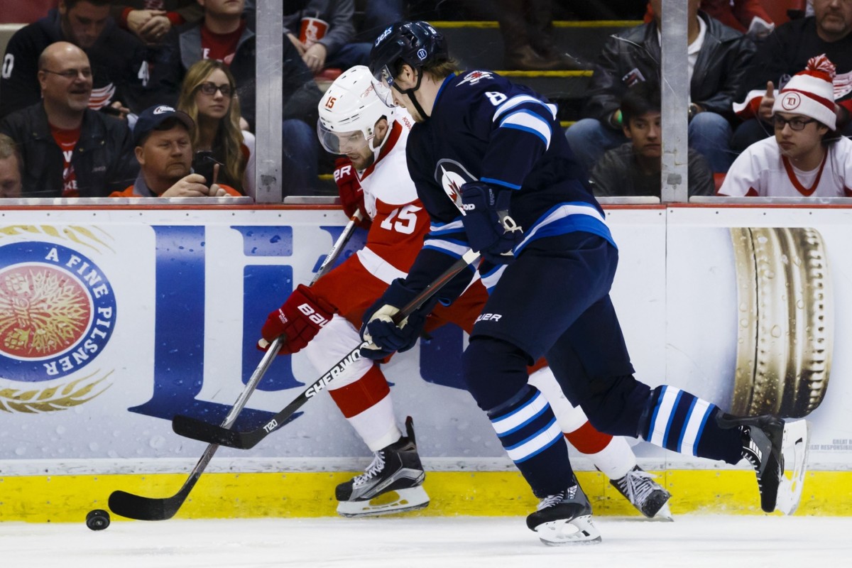 Jacob Trouba of the Winnipeg Jets and Riley Sheahan of the Detroit Red Wings