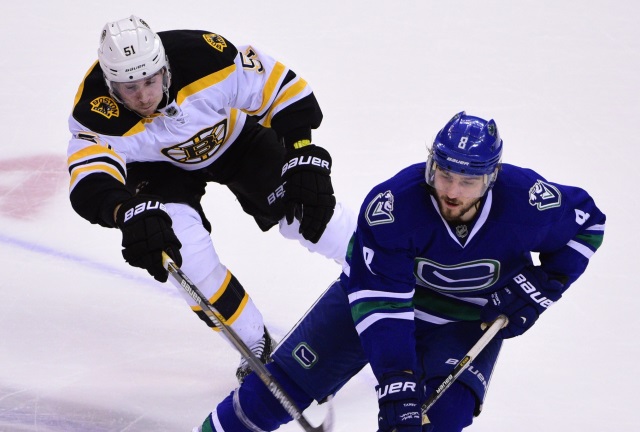 Ryan Spooner of the Boston Bruins and Chris Tanev of the Vancouver Canucks