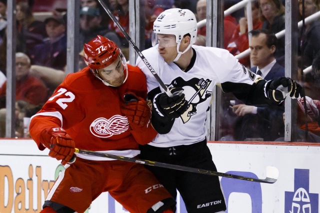 Andreas Athanasiou of the Detroit Red Wings and Ian Cole of the Pittsburgh Penguins